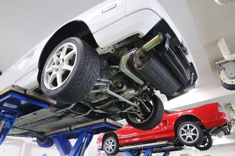 白い自動車と赤い自動車の整備のイメージ